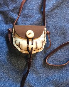 "This is a small hand stitched leather what not bag, in a brown colour leather with an embossed leather front, great for kids with change - or whatever. It measures approximately 3\" wide by2.5\" high by 1\"deep. It has a leather strap on it so it can be worn around the neck, and an antler, bone, or vintage button with a loop that can be pulled down to 'lock' it. Thanks for looking! Made in the USA!" Hand-stitched Leather Rectangular Coin Purse, Brown Hand Tooled Pouch, Hand-stitched Rectangular Leather Coin Purse, Leather Coin Purse With Mobile Phone Bag, Small Brown Bag For Gift, Small Brown Shoulder Bag For Everyday Use, Small Brown Gift Bag, Brown Hand Tooled Coin Purse Gift, Leather Hand-stitched Coin Purse For Everyday Use