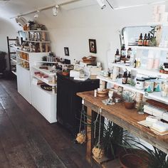 an old fashioned kitchen with lots of clutter on the counter and shelves above it