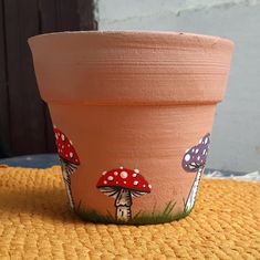 a clay pot with mushrooms painted on it