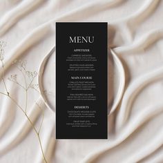 a black and white menu card sitting on top of a table