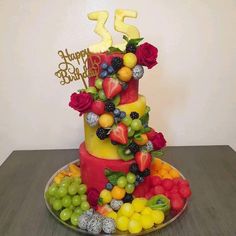 a birthday cake decorated with fruits and flowers