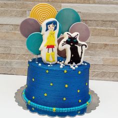 there is a blue cake decorated with balloons and two cats on the top one has an umbrella