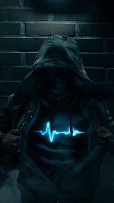 a man in a hoodie with a heart beat on his chest, standing against a brick wall