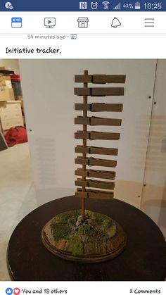 a sculpture made out of wooden sticks and moss on top of a table in a room