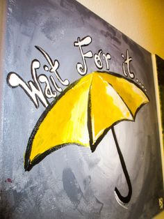 a yellow umbrella with the words wait for it painted on it in black and white