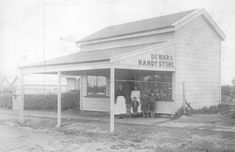 an old black and white photo of people standing in front of a store