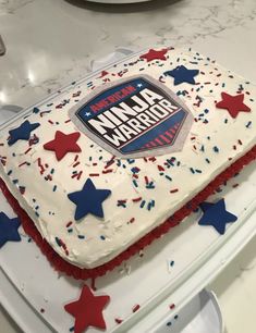 a cake that is sitting on top of a table with red, white and blue frosting