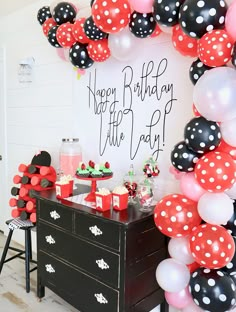 a birthday party with black, white and red balloons in the shape of polka dots