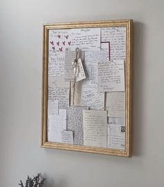 a wall covered in lots of papers and writing next to a vase filled with flowers