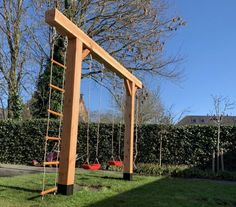 a wooden swing set sitting on top of a lush green field