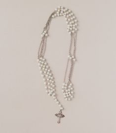 a necklace with pearls and a cross on it