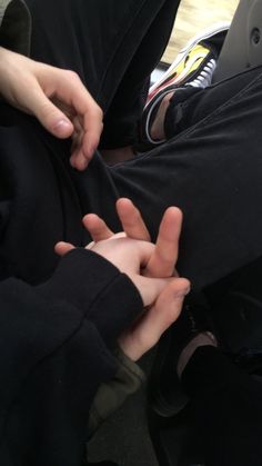 two people holding each other's hands while sitting down