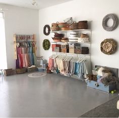 a room filled with lots of different types of clothing and baskets on the wall next to it