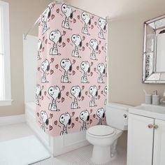 a bathroom with a shower curtain that has hearts on it, and a cartoon dog holding a heart in its mouth