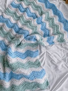 a crocheted blanket laying on top of a bed