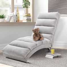 a teddy bear sitting on top of a chaise lounge chair in a living room