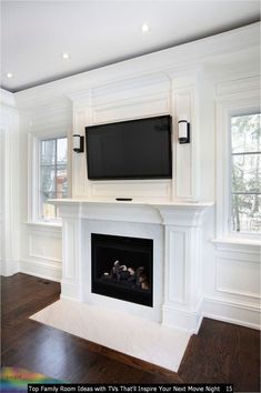 a white fireplace with a flat screen tv above it and wood floors in front of the fire place