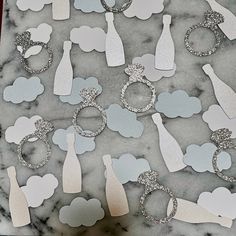 paper cutouts are arranged in the shape of wine bottles and clouds on a marble surface