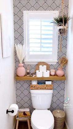 a white toilet sitting in a bathroom next to a window with shutters on it