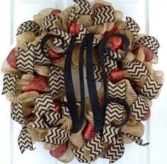 a burlock wreath with black ribbon and red bows on the front door,