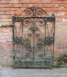 an iron gate on the side of a brick wall