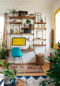 a desk with a computer and some books on the shelves in front of it,