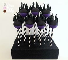 there are many black and white striped straws in the cupcake holders on this stand