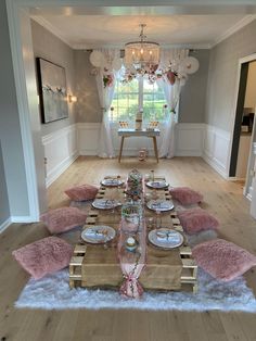 a dining room table set with plates and place settings