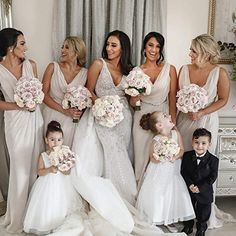 a group of women standing next to each other in front of a white table with flowers