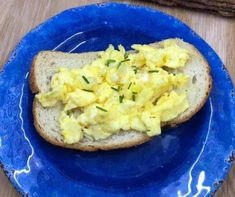 a blue plate topped with bread covered in scrambled eggs