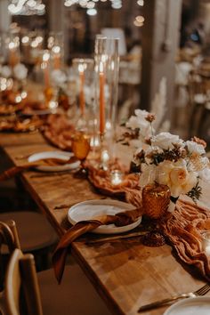 the table is set with candles, plates and napkins for an elegant wedding reception