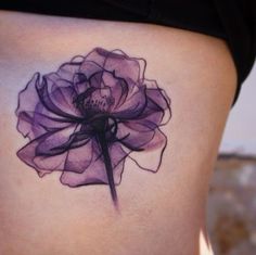 a woman's stomach with a purple flower tattoo on her lower back and side