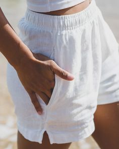 We love these breezy hemp linen shorts in white. They are a nice heavyweight linen and perfect for beach days and relaxing. Both classy and casual; these shorts are super versatile and essential to pack when headed to your favorite summer spots. Slight texture with a linen drape + feel Flattering, slightly boxy shape for casual wear Features pull-on design an elastic waistband Internal adjustable flat woven drawcord Two side slash pockets Unlined with vent/slit on side seam Men size up one or two sizes Female model in Washed White is 5'5" and wearing a size XS. Vacation Wardrobe, Hemp Fabric, Summer Getaway, Maternity Swimwear, Linen Short, Organic Cotton Fabric, Kids Pants, Female Model, Beach Shorts