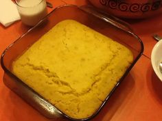 a pan filled with food sitting on top of a table next to a bowl and spoon