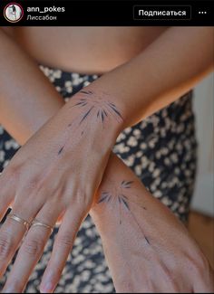 a woman's arm with tattoos on it and her hand holding the other arm