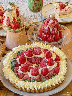 there is a cake with strawberries on it and other desserts in the background