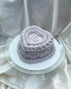 a white cake sitting on top of a glass plate