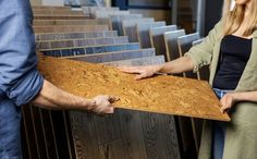 two people standing next to each other holding plywood planks in front of them