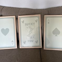 two framed playing cards sitting on top of a couch