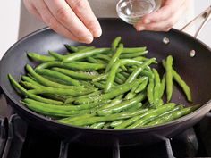 a person cooking green beans in a pan