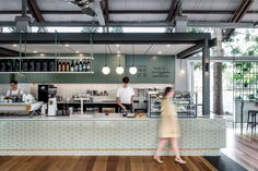 a woman walking past a counter in a restaurant