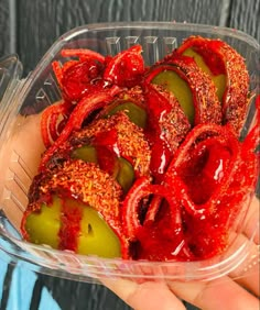 a plastic container filled with sliced peppers covered in ketchup