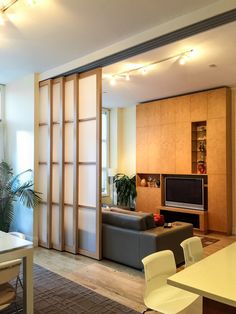 a living room filled with furniture and a flat screen tv on top of a wooden wall