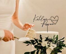 a bride and groom are cutting their wedding cake with the word happy married spelled on it