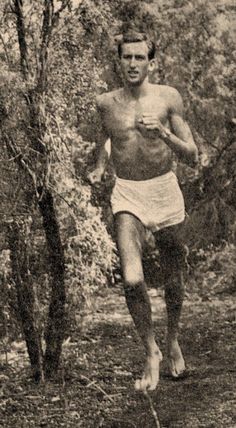 an old photo of a man running in the woods