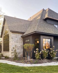 a house that has some flowers in the front yard and grass on the ground around it