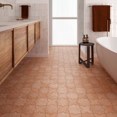 a bathroom with an orange tiled floor and wooden cabinetry next to the bathtub