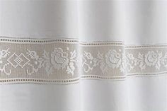 a white curtain with an embroidered design on it