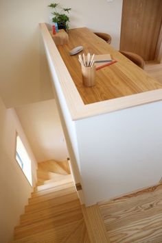 a wooden desk sitting on top of a hard wood floor next to a doorway and stairs