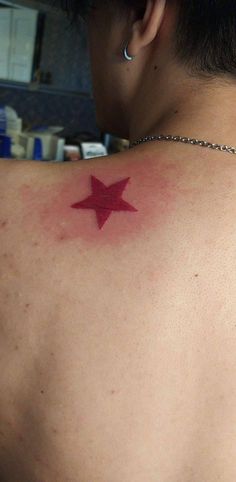 a person with a red star tattoo on their back